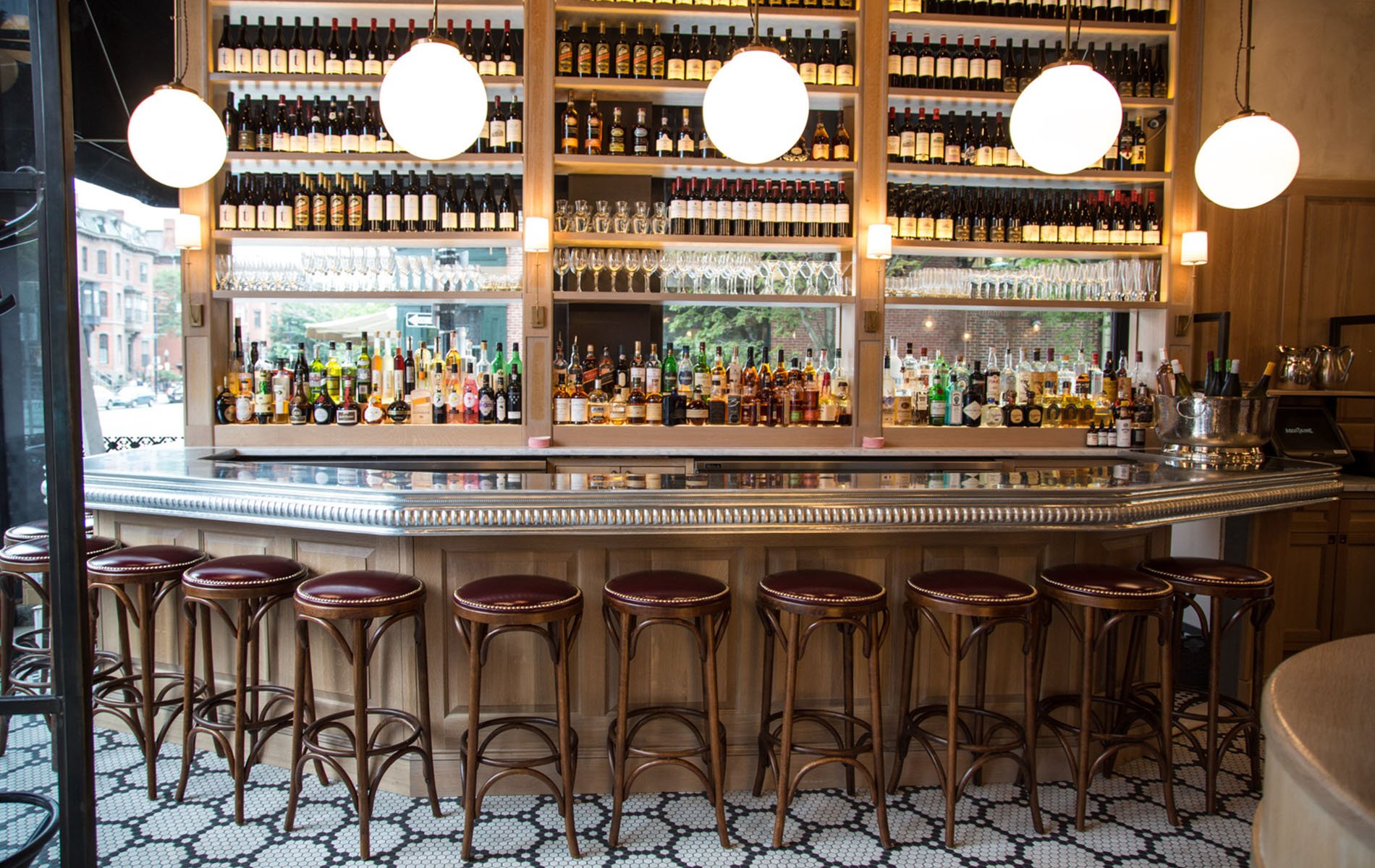 parisan style bar with white globe lights and colorful bottles