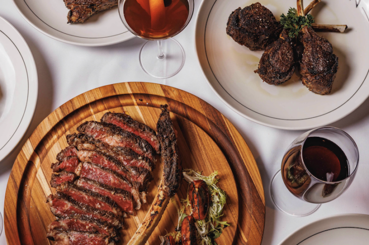 multiple plates of food including sliced steak from Avra Boston