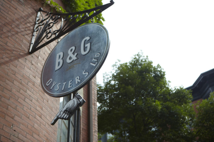 black B&G sign with red brick and green tree