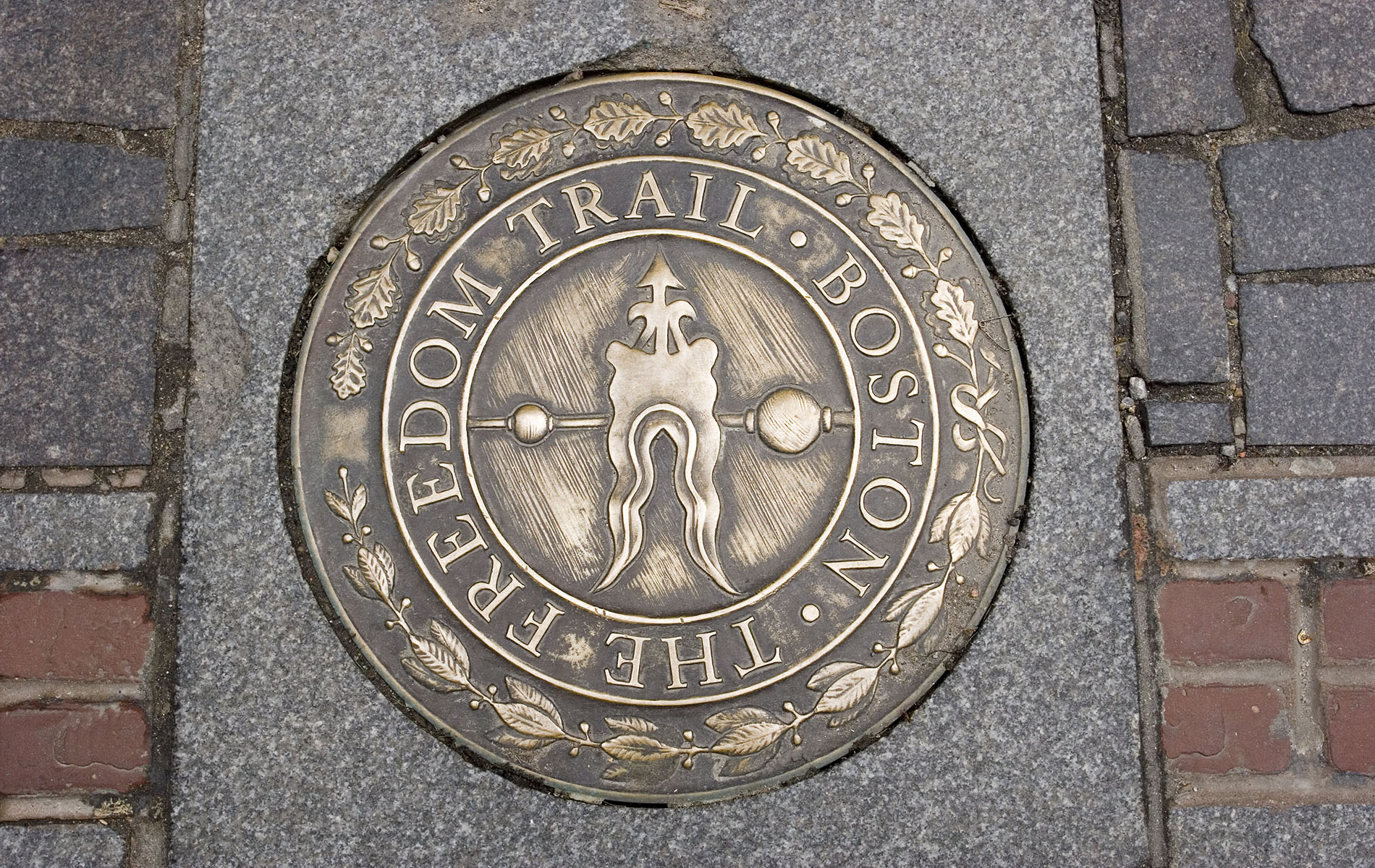 Freedom Trail bronze plaque on cement with red brick line