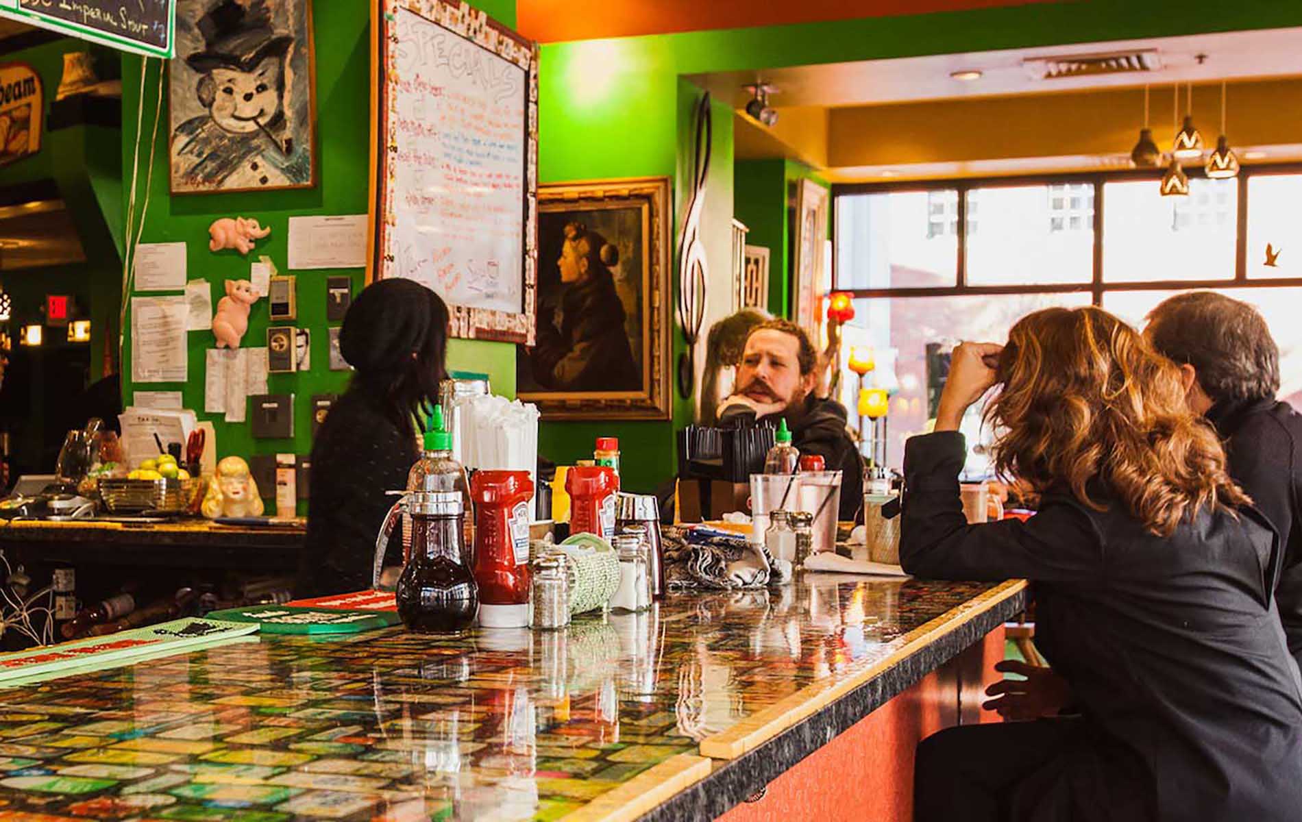 colorful bar top with green walls and a few people sitting