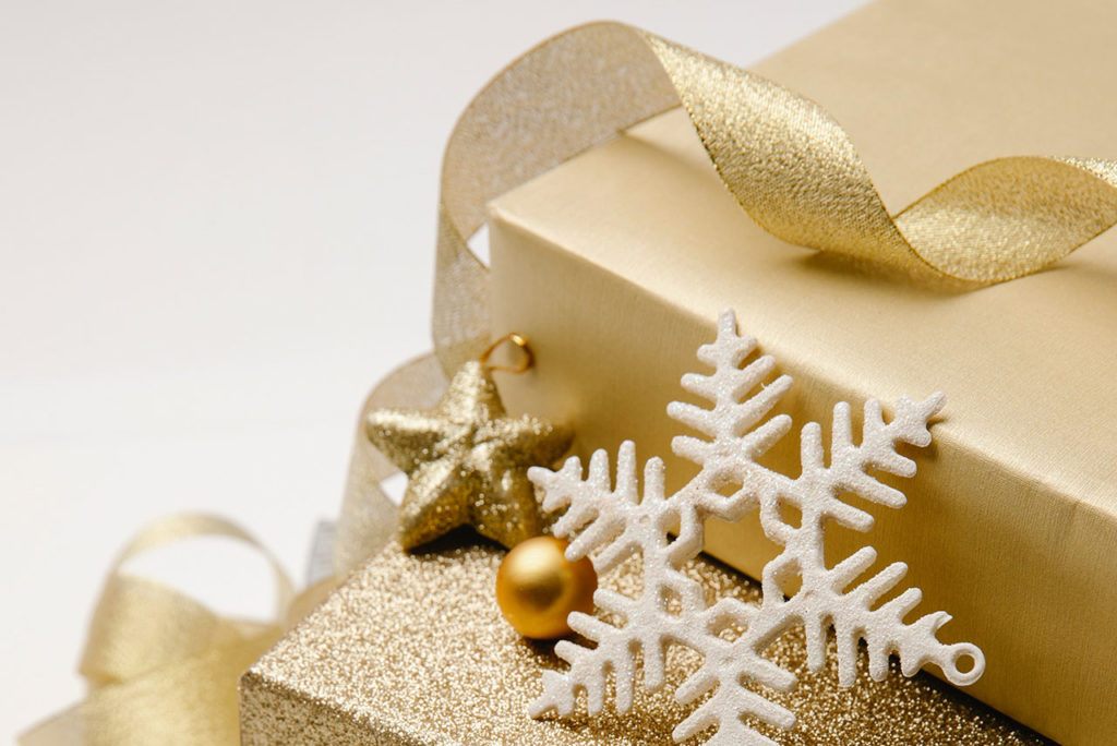 Gold and white gift box, ribbon and snowflake.