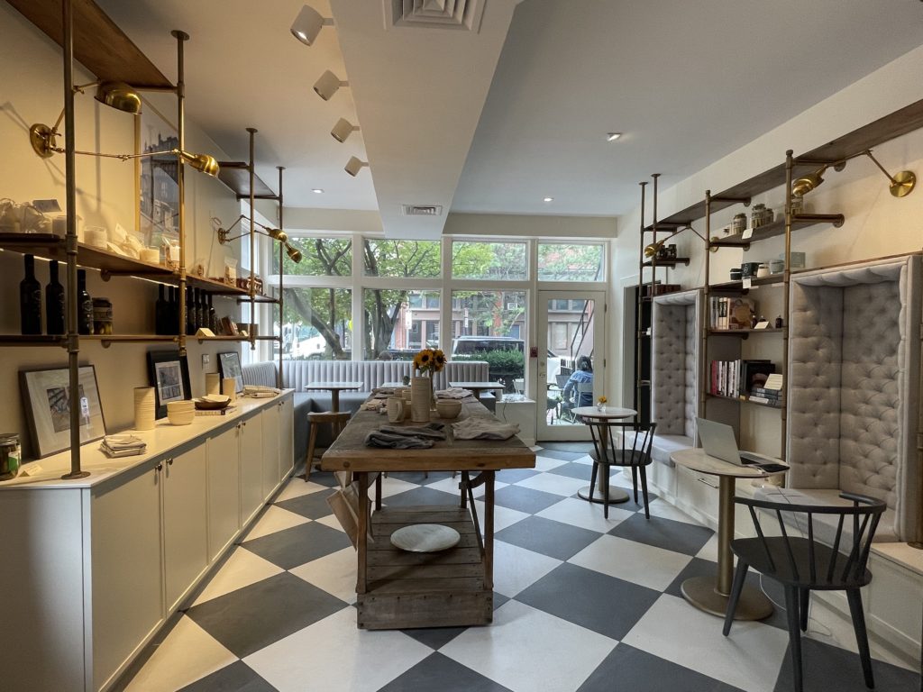 black and white checkered floor in cafe with one table and one booth along windows