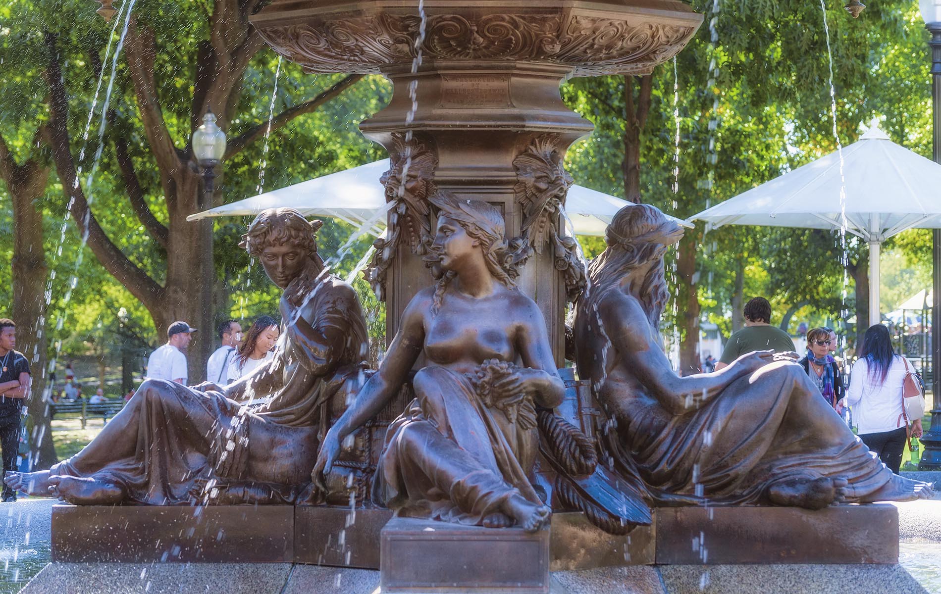 water fountain brown stone base with three women carved into with water flowing