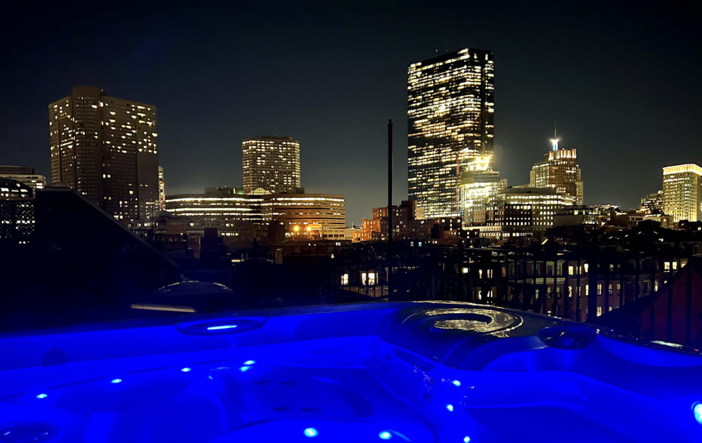 Deep blue water in hot tub, dark city skyline views of city lights