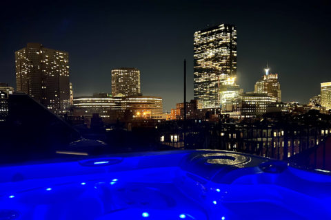 Deep blue water in hot tub, dark city skyline views of city lights