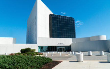 Modern building with white triangular section and black glass cube and blue sky