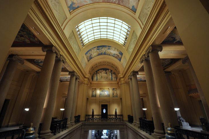 museum with sky light in a central room with 6 grey stone columns