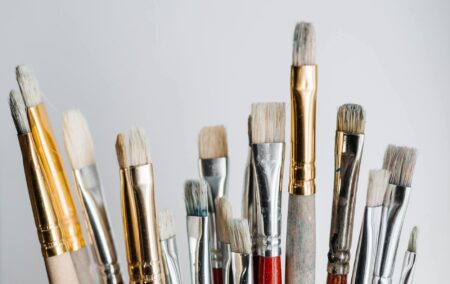 various paintbrushes upright silver gold and red accents