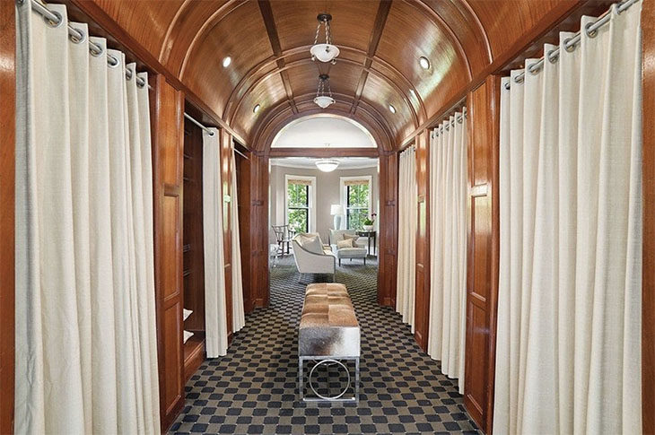 View of white modern freestanding tub through a wood hallway with mahogany barrel vault ceiling