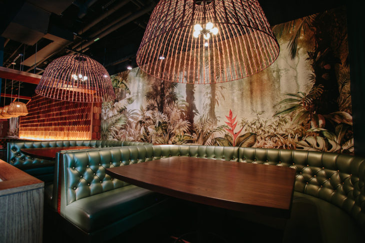 green tufted booth with wood table and beaded chandelier