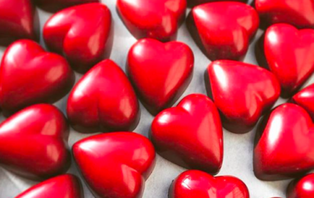 dozens of red chocolate truffles in a heart shape