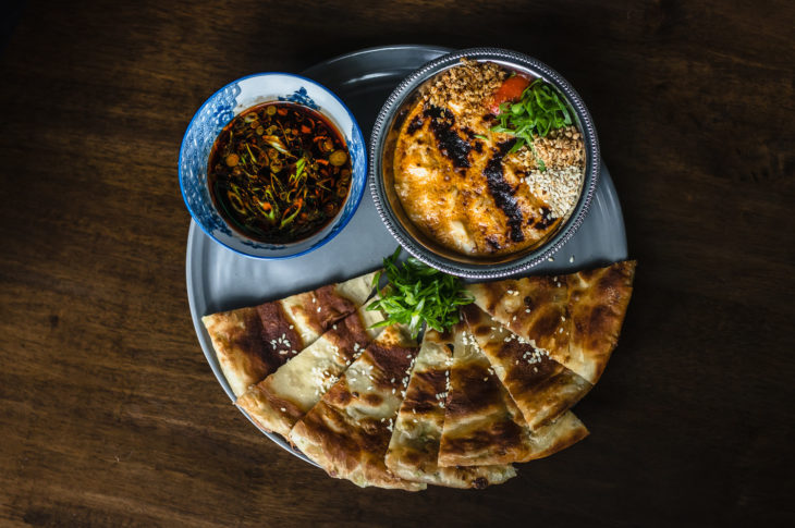 platter with two round dip bowls and triangle breads on wood