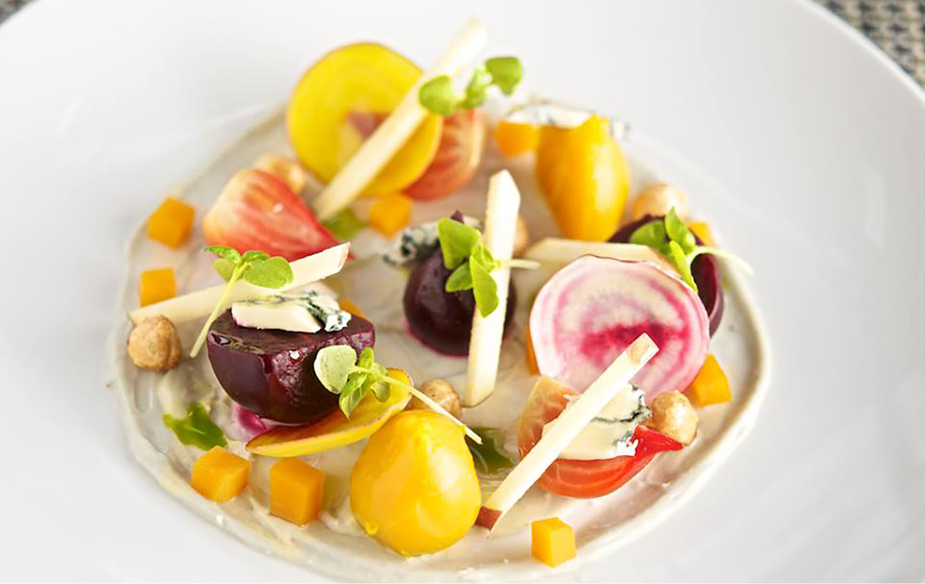 colorful plate of slice red and yellow beets and pieces of beef