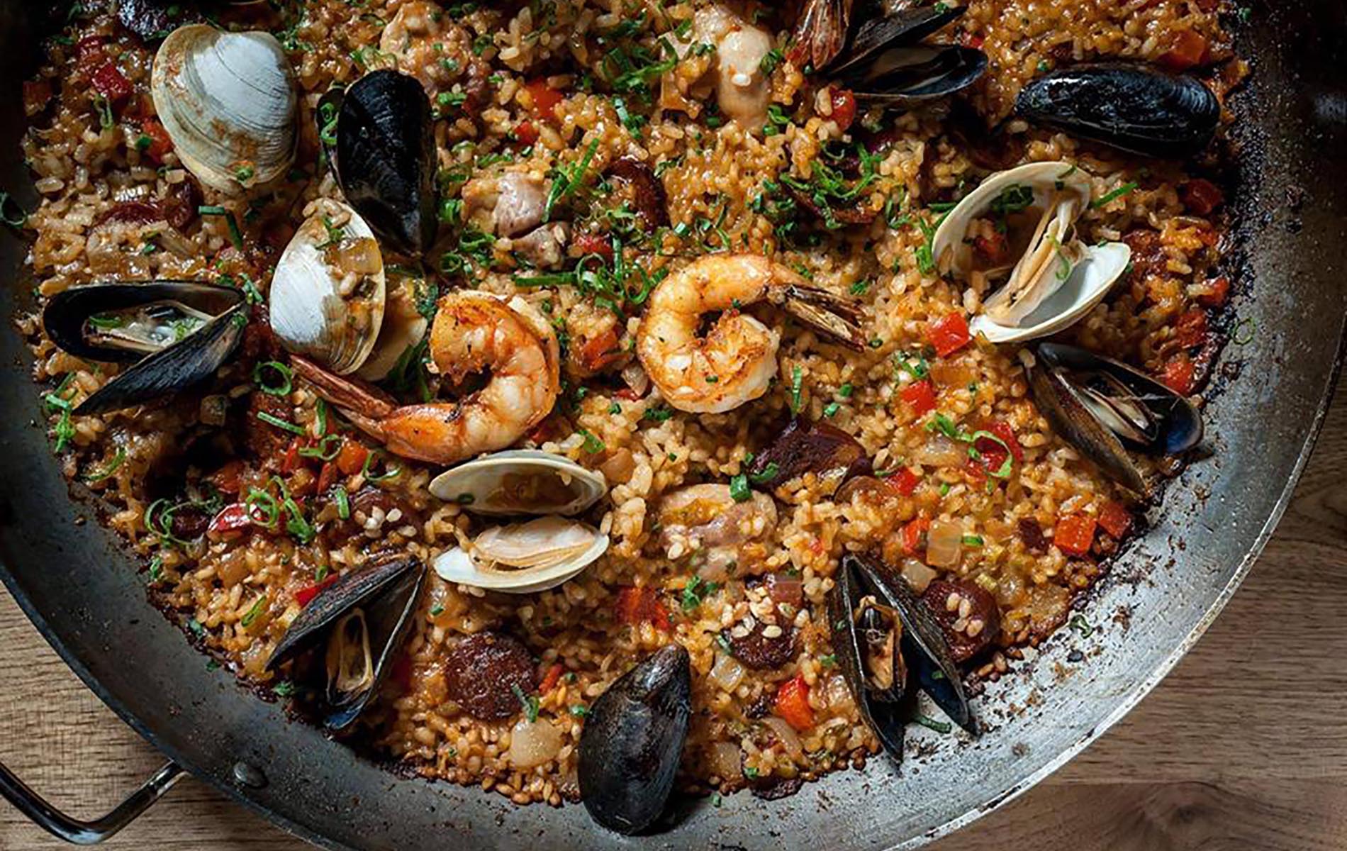 paella in a metal pan with black mussels and shrimp