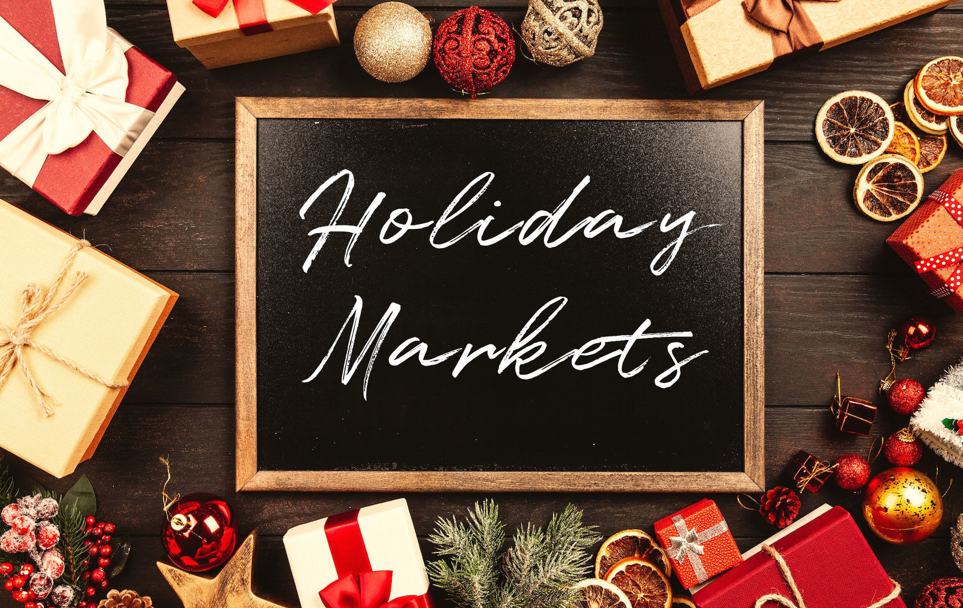 red and white gift and ball ornaments around a black chalkboard that says holiday markets in white writing