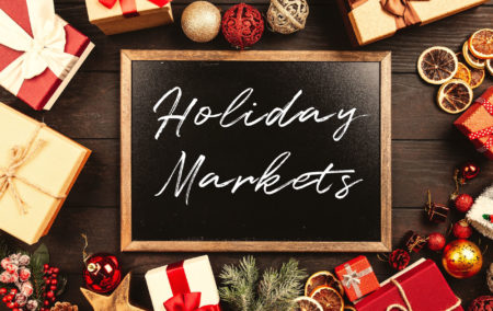 red and white gift and ball ornaments around a black chalkboard that says holiday markets in white writing