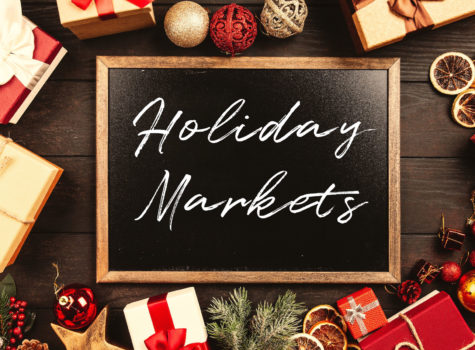 red and white gift and ball ornaments around a black chalkboard that says holiday markets in white writing