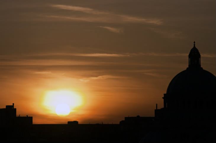 Black silhouette of buildings against a beautiful orange sunset