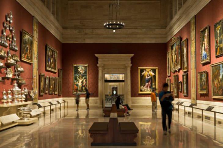 Marble room with red walls and old paintings