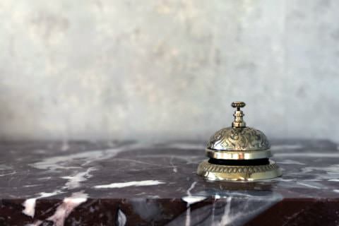 Close-up view of a gold ornate service bell on a stone countertop