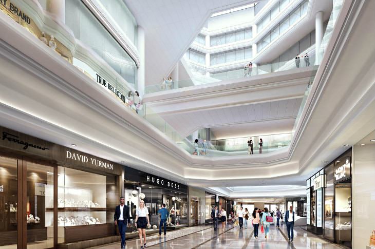 Elegant mall aisle of stores with multiple floors, white columns and glass railings