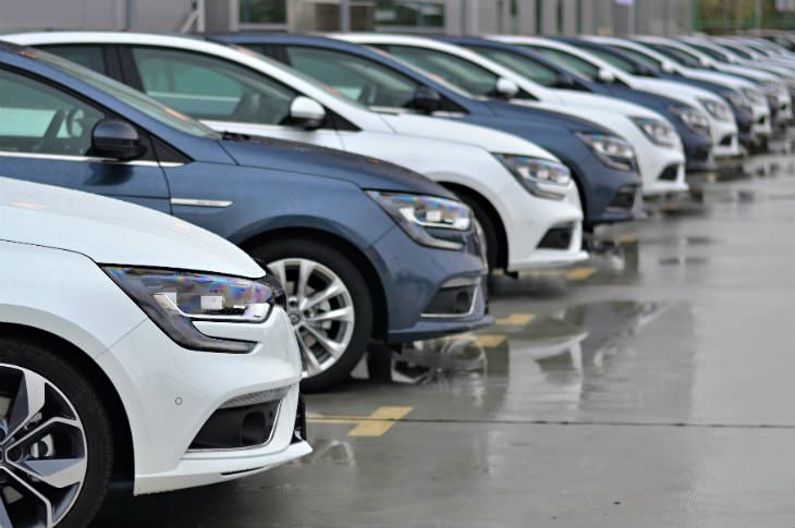 Evenly spaced, alternating blue and white cars parked at an angle